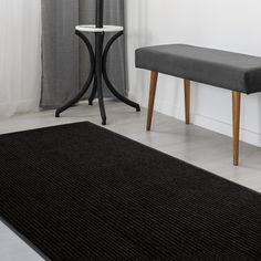 a black rug with a bench next to it