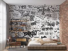 a bedroom with graffiti written on the wall and bed in front of a brick wall