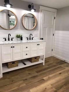 a bathroom with double sinks and two mirrors on the wall next to eachother