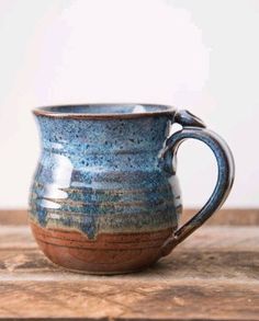 a blue and brown mug sitting on top of a wooden table