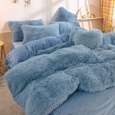 a bed with blue comforters and pillows in a bedroom