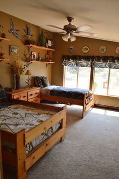 a bedroom with two twin beds and shelves on the wall, along with a ceiling fan