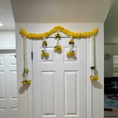 a white door decorated with yellow flowers and chains