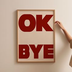 a woman is holding up a poster with the words ok bye in red on it