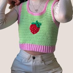 a woman wearing a green and pink knitted top with a strawberry on the front