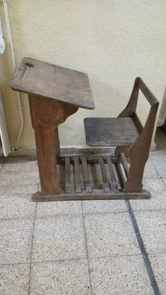 an old wooden chair sitting on top of a tile floor