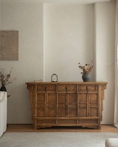 a large wooden cabinet sitting in the middle of a living room next to a window