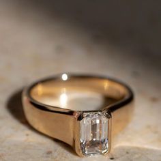 a close up of a ring with a diamond on it's side and a light in the background