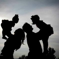 three people are silhouetted against the sky with their arms around each other as they look at something