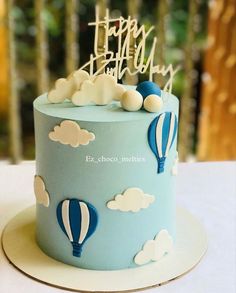 a blue and white birthday cake with hot air balloons