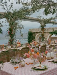 an outdoor dining area with tables, chairs and flowers on the tablecloths is shown