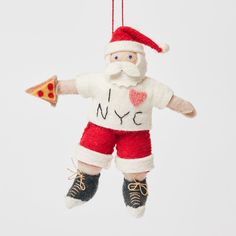 a christmas ornament with a santa clause holding a slice of pizza in his hand