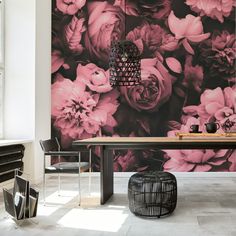 a dining room table with flowers on the wall behind it