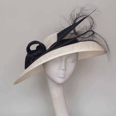 Make a statement in this elegant contemporary sweeping hat. Featuring white sinamay , wide brim, small crown with  navy silk abaca twists. Stunning burned ostrich feather and shaped navy feather.  This hat looks equally stunning with black trim. A hat for those who wish to remain noticeably unnoticed. Shipping to the USA  is by courier. For destinations not listed please ask for a shipping quotation. This hat can be made in many colours  please enquire. Navy Fascinator, Special Occasion Hats, Mother Of The Bride Hats, Formal Hat, Small Crown, Royal Ascot Hats, Ascot Hats, Church Hat, Bride Hat