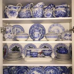 blue and white china is displayed on shelves