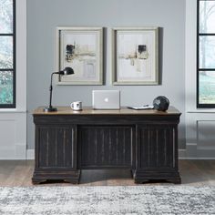 an office with two framed pictures on the wall and a desk in front of it