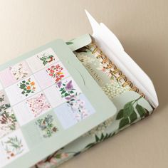 the inside of a planner book with flowers and leaves on it's cover is open