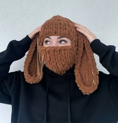 a woman wearing a brown knitted hat covering her face