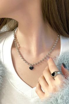 Get ready to rock the glam punk vibes with our Heartbreaker Necklace. This statement piece features a thick 4mm ball chain that exudes edgy style. The centerpiece is a heart charm, painted in monochrome for a bold and eye-catching look. The combination of the chunky chain and the punk-inspired heart charm creates a perfect blend of retro and contemporary aesthetics. - Chain: approx. 17", Nickel-free Alloy- Charm: approx. 12mm (0.47"), Nickel-free Alloy, Epoxy Trendy Metal Heart Necklace With Heart Beads, Trendy Metal Heart Necklace For Everyday, Trendy Everyday Metal Heart Necklace, Trendy Metal Heart Beads Necklace, Trendy Silver Heart Necklace, Trendy Metal Heart Necklace, Trendy Black Jewelry With Heart Beads, Trendy Black Heart Beads Jewelry, Trendy Black Heart Charm Necklace