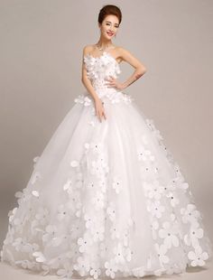 a woman in a white wedding dress with flowers on it, posing for the camera