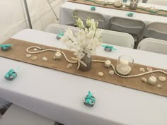 the table is set with candles, flowers and seashells for an ocean themed party