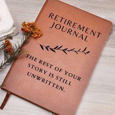 an orange book with the words retirement journal on it next to some flowers and towels