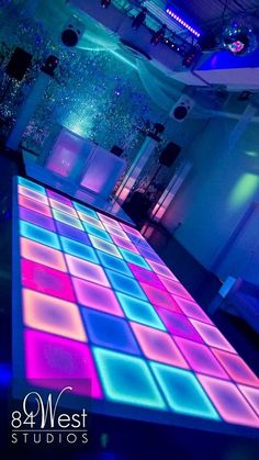 the dance floor is lit up with colorful lights