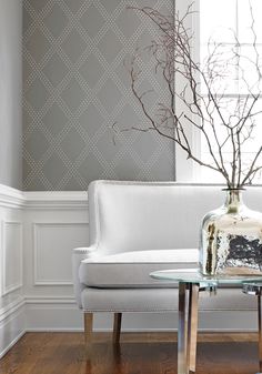 a white couch sitting next to a table with a vase filled with flowers on top of it