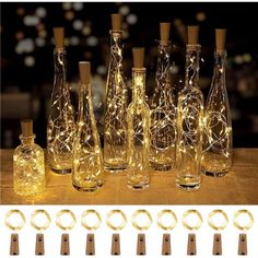 bottles with lights in them sitting on a table next to other bottles and glasses that are lit up