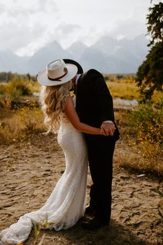 a bride and groom kissing in the desert