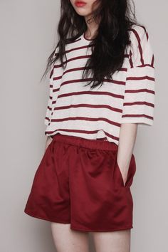 a woman wearing red shorts and a striped shirt