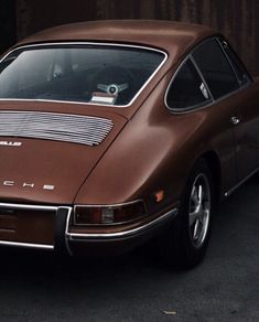 a brown porsche parked in front of a building