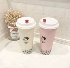 two coffee cups sitting next to each other on a counter