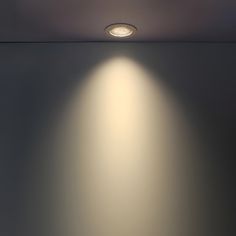 an empty room with two lights on the ceiling and one light on the wall above it