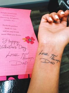 a woman's arm with a pink card and flowers on it that says happy valentine day