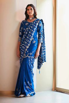 Editor's Note Featuring Blue Jade Leher Embroidered Saree Set with Hand Embroidered, Zardozi, French Knots Fabric: Benarse Weave Color: Blue Jade Care: Dry Clean Only About the Designer A melange of rich embroideries, appliques, impeccable weaving, brilliant printing, and dyeing, Osaa by Adarsh is a story of India’s rich textile traditions replicated to form wedding couture. Adarsh Makharia saw the endless opportunities to engage the diverse artisans and designs and, with Osaa, weaved together a Blouse Design For Banarasi Saree, Saree Ideas, Embroidered Saree, Blue Saree, French Knots, Banarasi Saree, Indian Wedding Outfits, Embroidered Neckline, Indian Fashion Designers