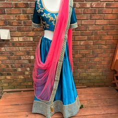 3 Piece Readymade Lehenga Choli. Comes With Blouse, Lehenga Skirt, Dupatta Go Over The Blouse. Very Pretty Blue And Pink Color Silk Lehenga. *Price Is Firm. Lowered Best I Could. It Has Been Worn Once At An Event. It's In Excellent Condition. No Flaws. Skirt Length: 43 Inch Blouse: 36 Margin: 4 Inch Material: Silk And Net Dupatta Festive Blue Wedding Skirt, Blue Silk Floor-length Lehenga, Fitted Blue Silk Sharara, Designer Wear Traditional Drape Skirt For Navratri, Designer Traditional Drape Skirt With Zari Work, Traditional Drape Skirt With Zari Work, Blue Silk Lehenga For Navratri, Fitted Blue Art Silk Sharara, Silk Wedding Skirt With Traditional Drape