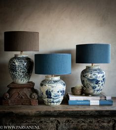 two blue and white vases sitting on top of a table next to a lamp