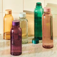 several different colored bottles sitting on a counter