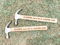 two hammers laying on the ground with some words written on them