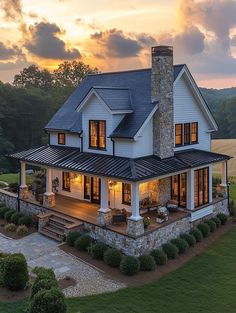 an aerial view of a large house with a stone chimney and covered patio at sunset