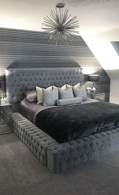 a large bed sitting in the middle of a bedroom next to two lamps on either side of it