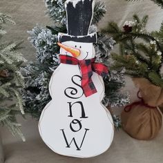 a snowman ornament sitting on top of a tree