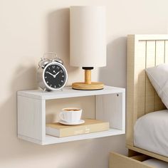 an alarm clock on a shelf next to a coffee cup and lamp in a bedroom