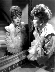 an old black and white photo of two women in front of a mirror looking at each other