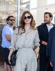 a woman is walking down the street wearing sunglasses