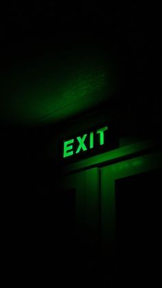 an exit sign lit up in the dark