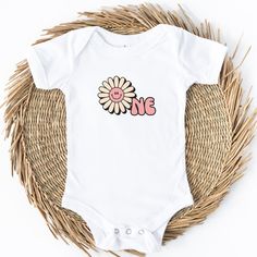 Introducing the Groovy One Daisy Baby Bodysuit - the perfect outfit to celebrate your little one's 1st birthday in style! This adorable bodysuit is designed with utmost love and care to make your baby look absolutely groovy  on their special day. Crafted from soft and breathable cotton fabric, the Groovy One Daisy Bodysuit ensures your baby's comfort throughout the day. It features a delightful daisy pattern that exudes a playful and cheerful vibe, creating a truly groovy look.  With its convenient snap-button closure at the bottom, dressing and diaper changes become a breeze. The bodysuit offers a perfect fit and allows your baby to move freely and explore their surroundings comfortably. Whether they're crawling, playing, or enjoying their first taste of birthday cake, this outfit ensures Spring First Birthday Bodysuit, First Birthday Spring Bodysuit, Personalized Cute Onesie For First Birthday, Playful Cotton Onesie For First Birthday, Personalized Fitted Onesie For Birthday, Fitted Onesie With Letter Print For First Birthday, Fitted Letter Print Onesie For First Birthday, First Birthday Spring Cotton Bodysuit, Cute Short Sleeve Onesie For First Birthday