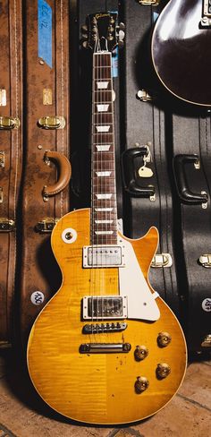 a yellow electric guitar sitting next to some suitcases