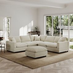 a living room with white furniture and large windows